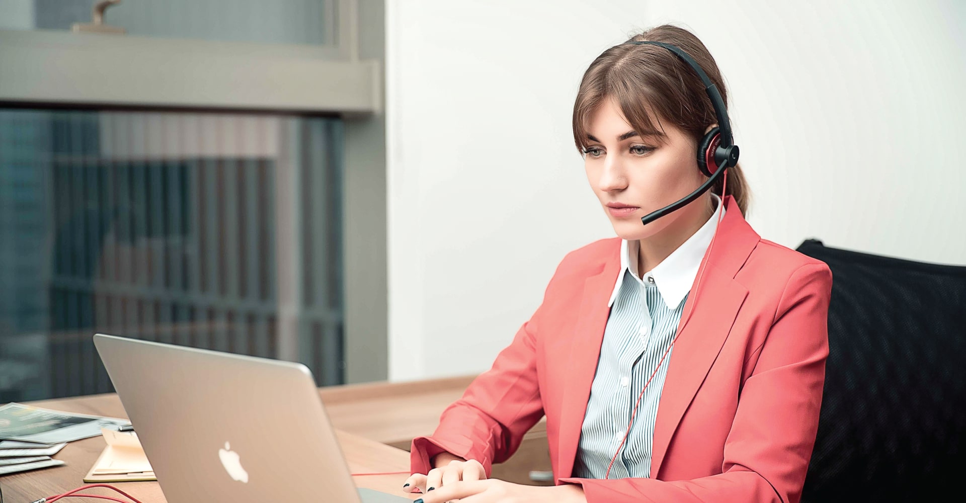 An office worker using wired Addasound USB headset EPIC 502 on laptop