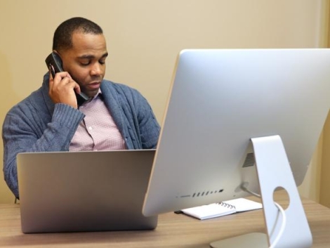 A4362 mitel-man-on-mitel-phone-at-desk-using-computer