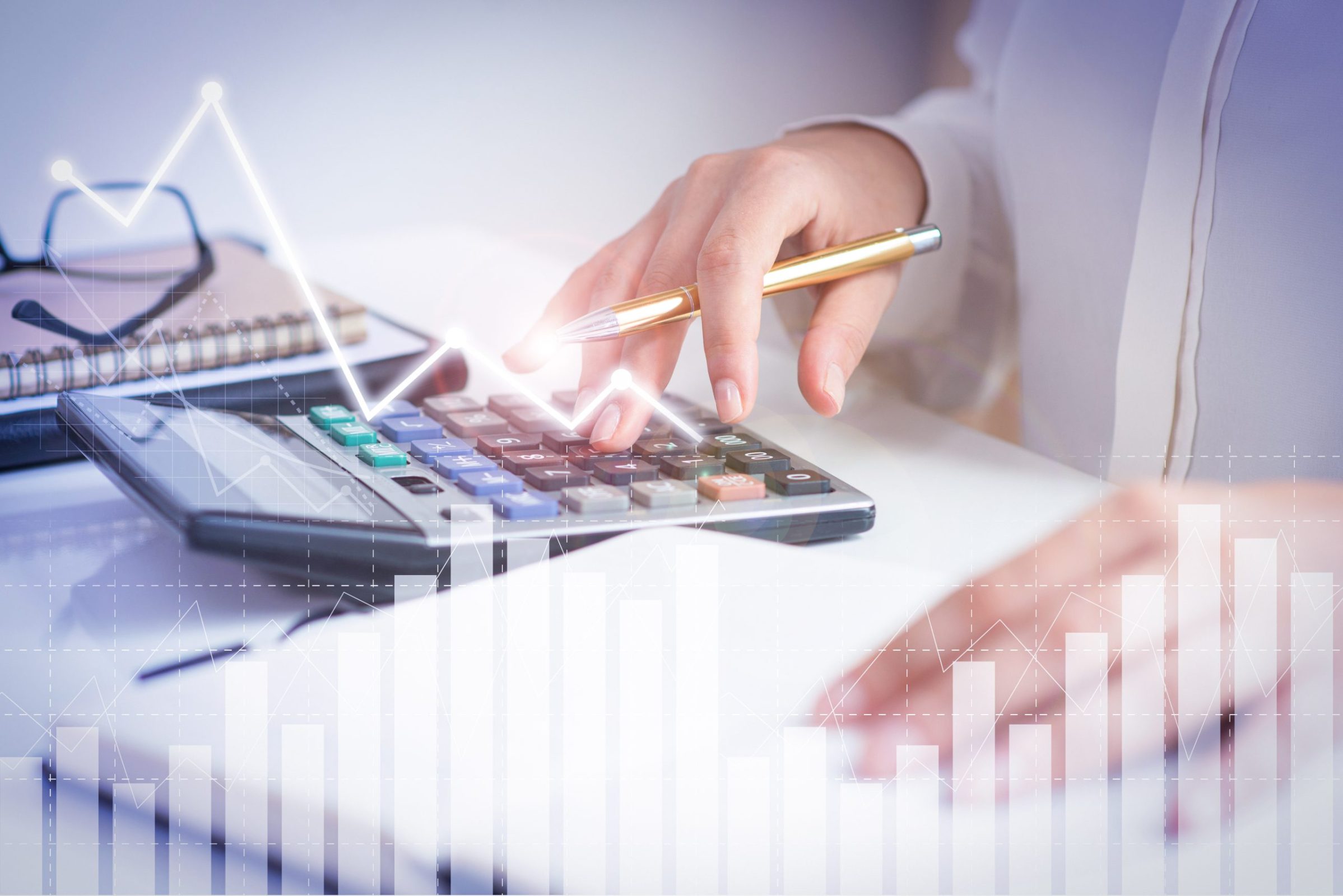 Accountant calculating profit with financial analysis graphs Accountant calculating profit with financial analysis graphs. Notebook, glasses and calculator lying on desk. Accountancy concept. Cropped view.