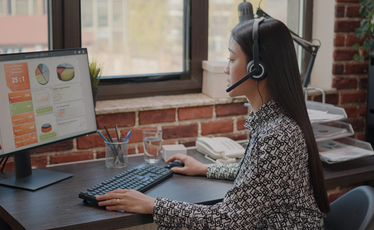 Close up of asian woman with headphones talking on phone call Close up of asian woman with headphones talking on phone call to people at customer service. Consultant using headset and microphone, working at call center on computer. Support chat